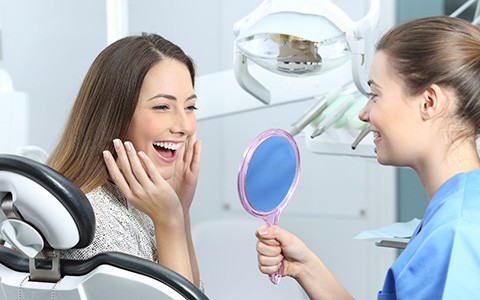 a patient smiling after receiving dental implants
