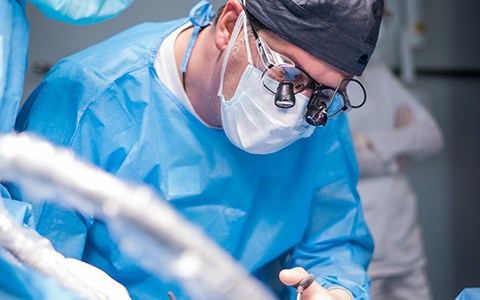 dentist showing a patient a model of a dental implant
