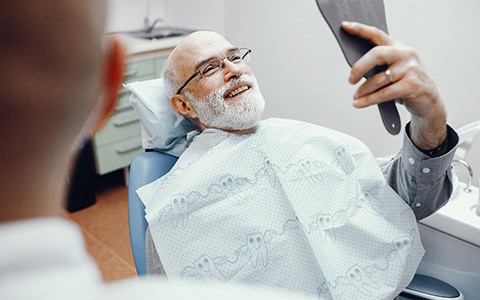 dentist showing a patient a model of a dental implant