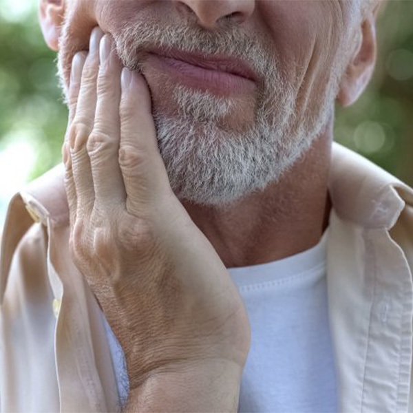 Man rubbing his aching jaw.