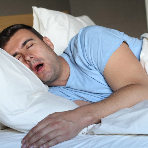 Man snoring while sleeping in his bed.